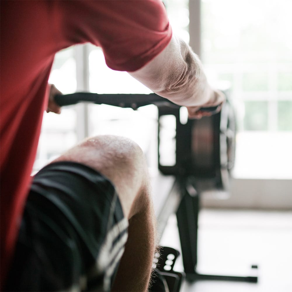 Gym Info 1 man exercising at the gym with a rowing machine